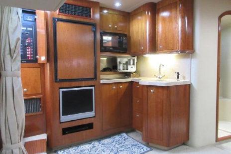 2005 Cruisers Yachts 370 Express interior kitchen with wood cabinetry and modern appliances.