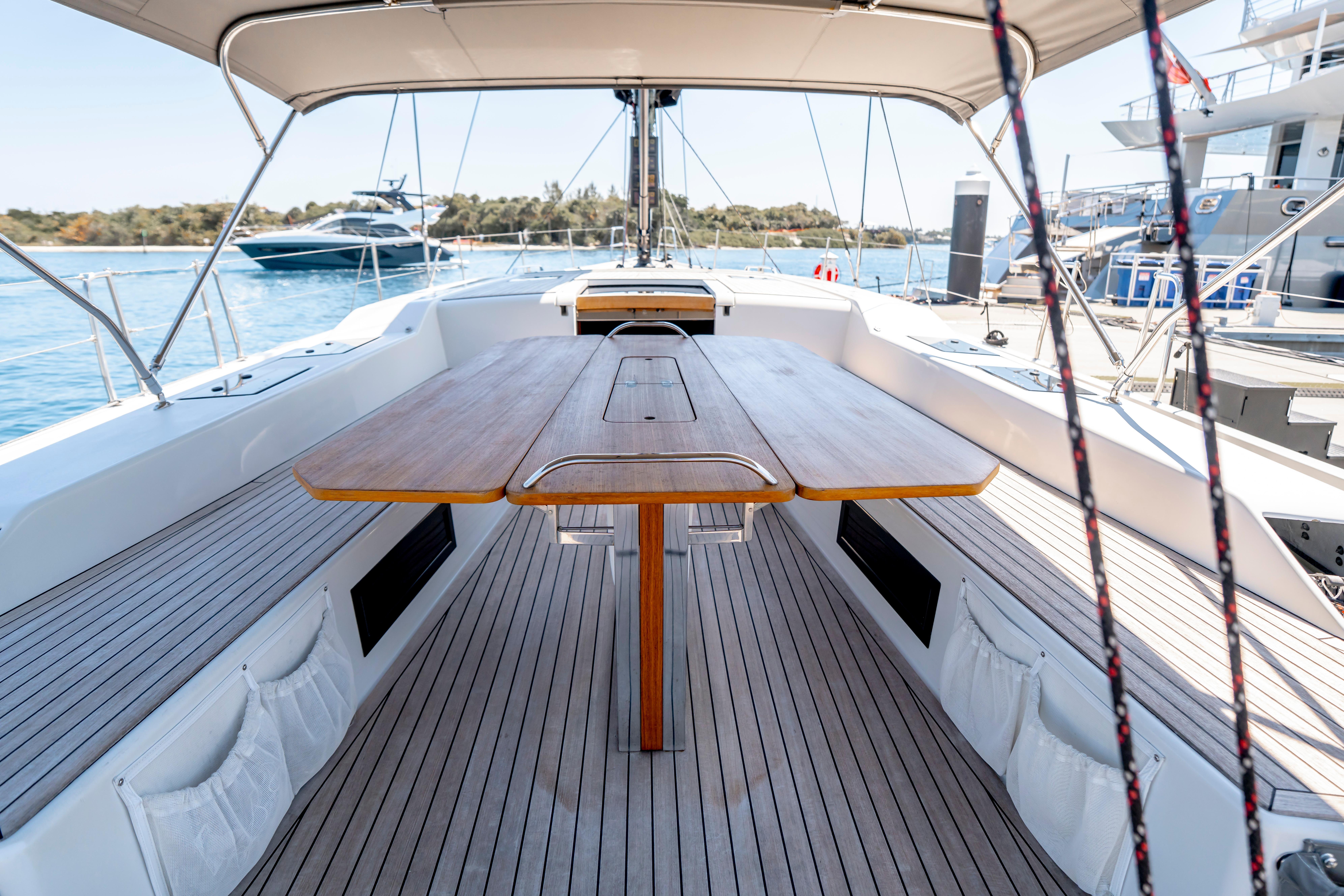 Spacious deck of 2016 Grand Soleil 58 yacht with elegant wooden table and seating.