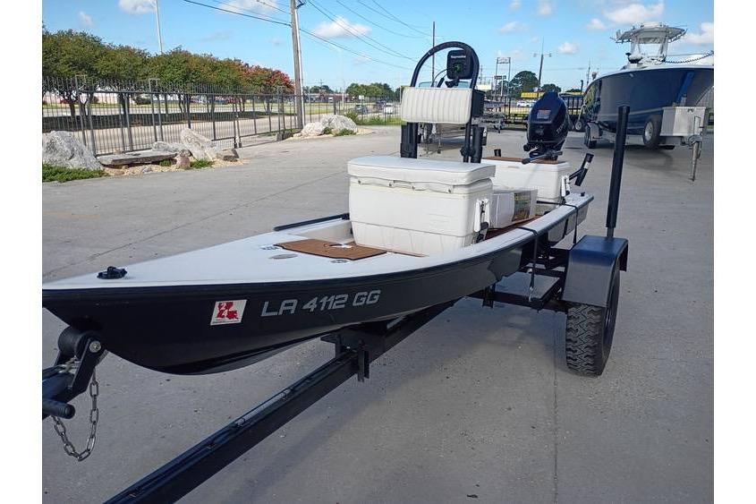 2013 Pelican Ambush boat on trailer with motor and seating, parked outdoors.
