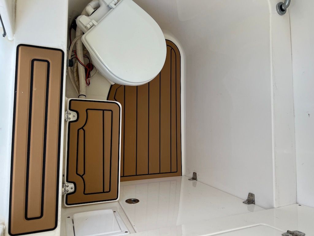 Interior of a 2006 Venture 39 Open with toilet and wood flooring.
