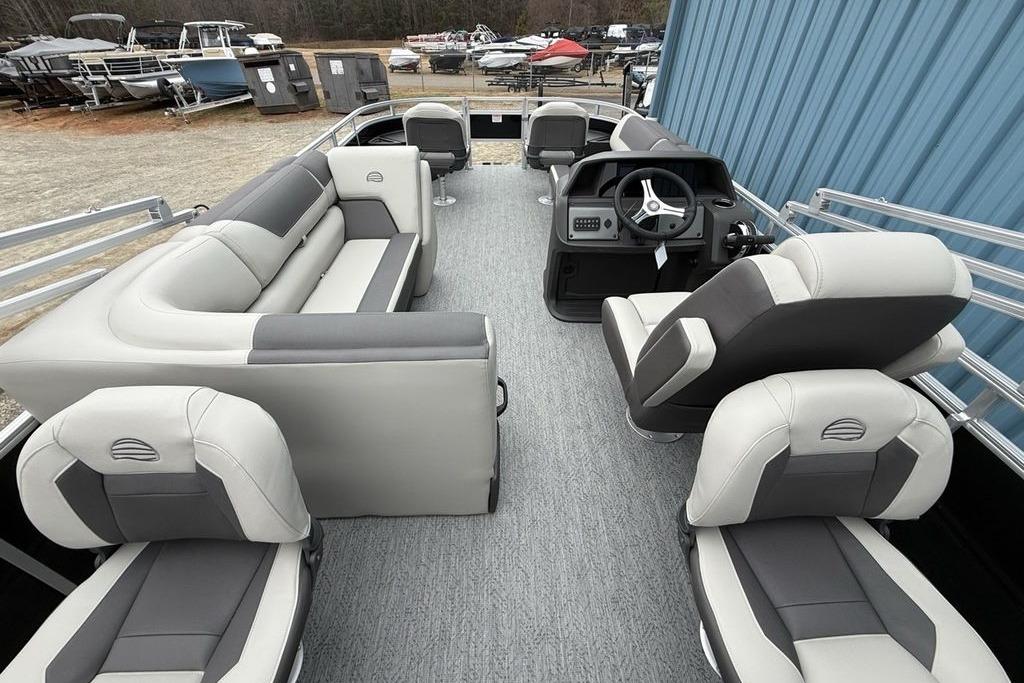 2026 Sun Tracker Fishin' Barge 20 DLX interior with plush seating and steering console.