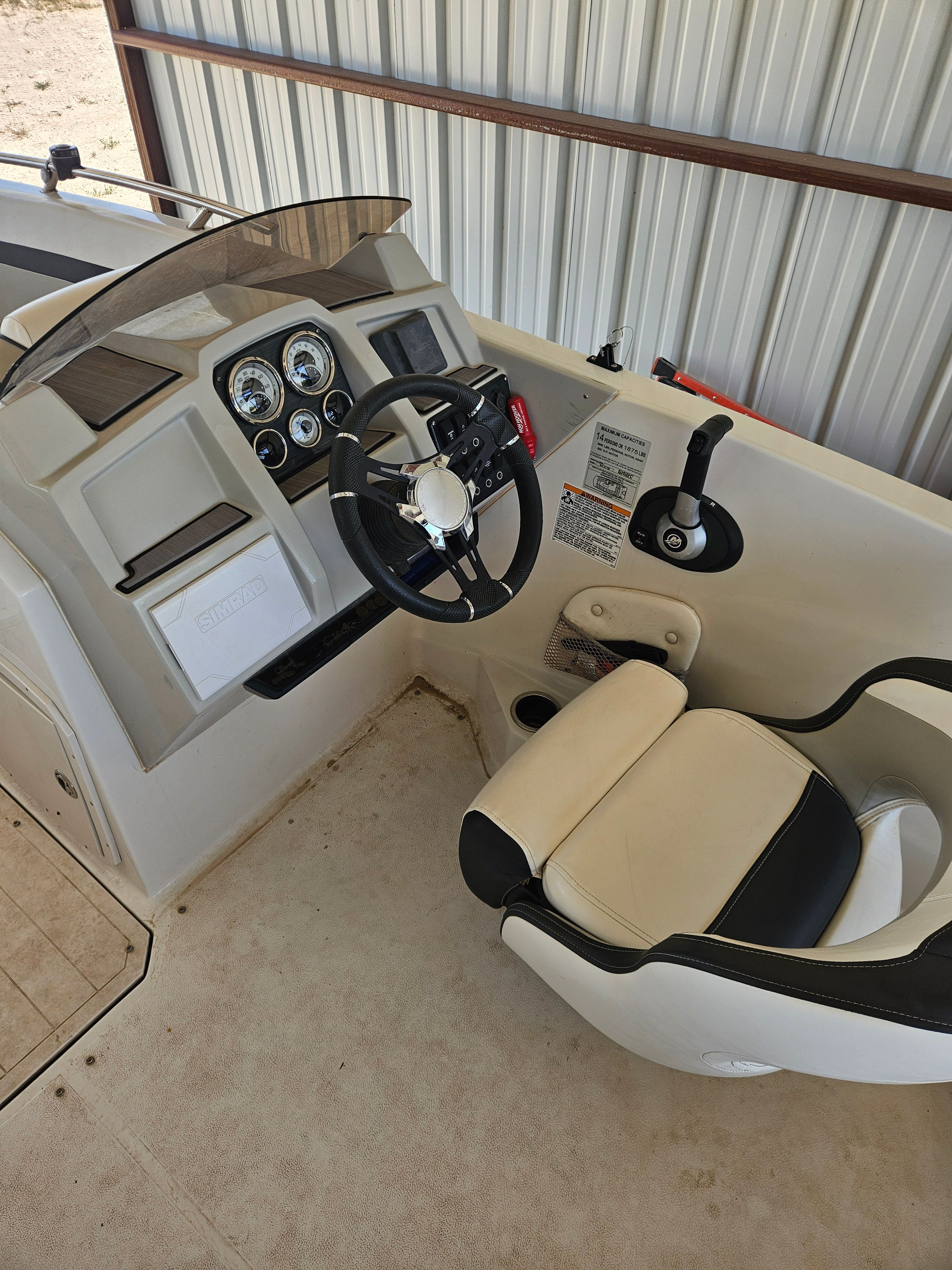 The image shows the cockpit of a 2023 Starcraft SVX211 boat with a helm and seat.