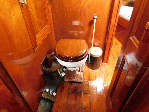 1983 Custom Murray Peterson Coaster III boat interior with wooden toilet and polished wood finish.