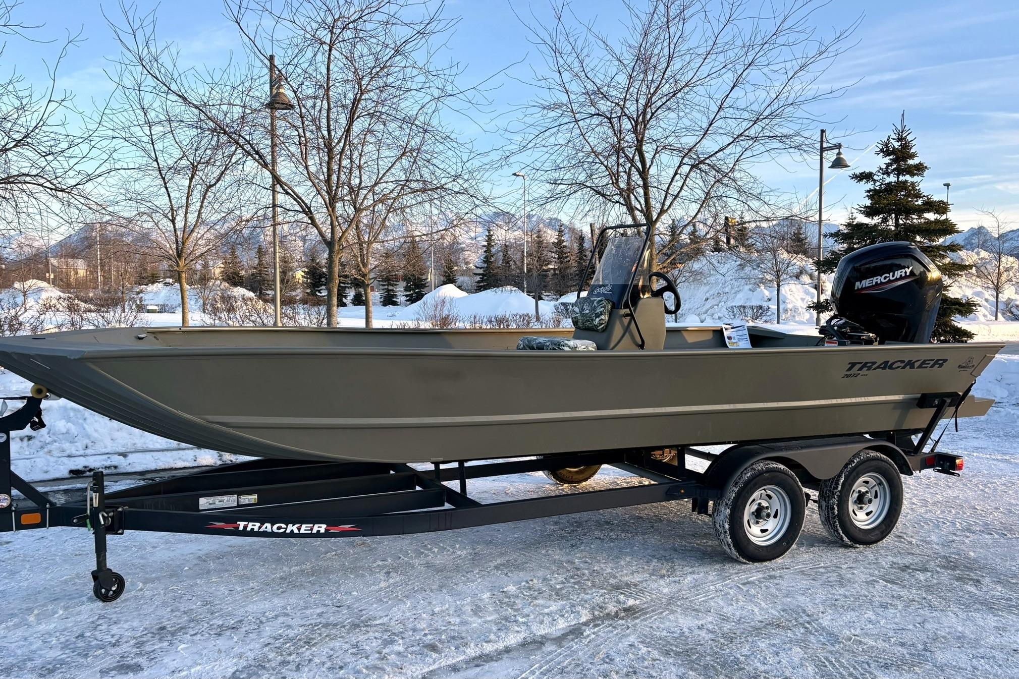 2024 Tracker Grizzly 2072 CC boat on trailer in snowy landscape.