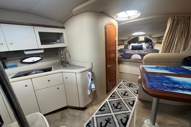 Interior of 2004 Cruisers Yachts 3372 Express with kitchenette and cozy sleeping area.