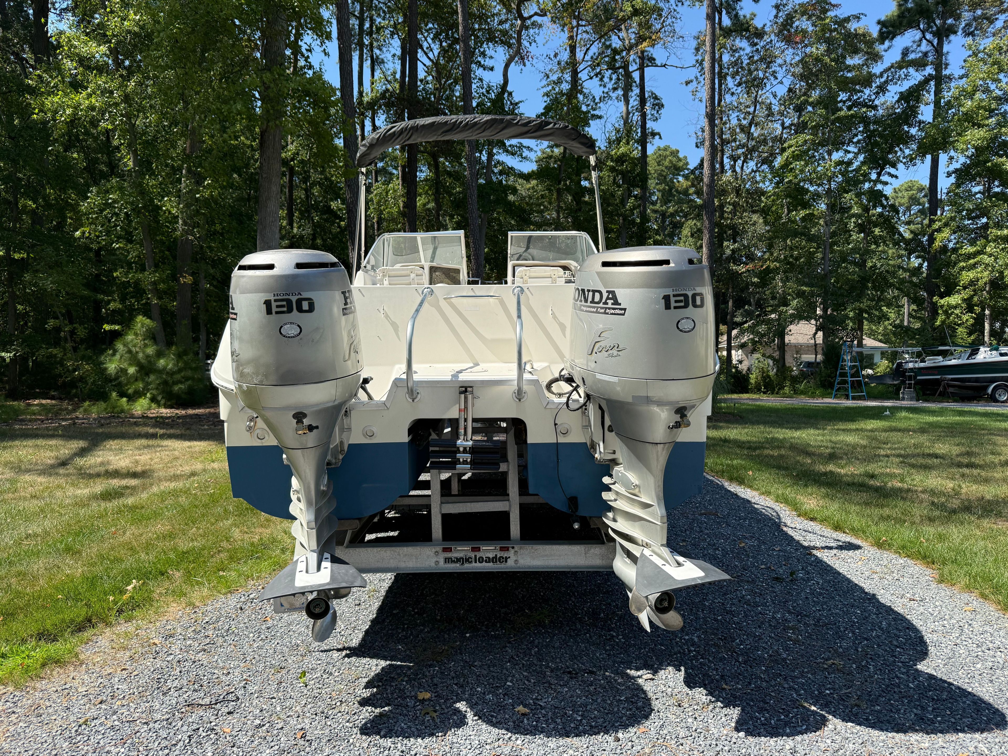 2002 World Cat 246 DC boat with Honda 130 engines outdoors.