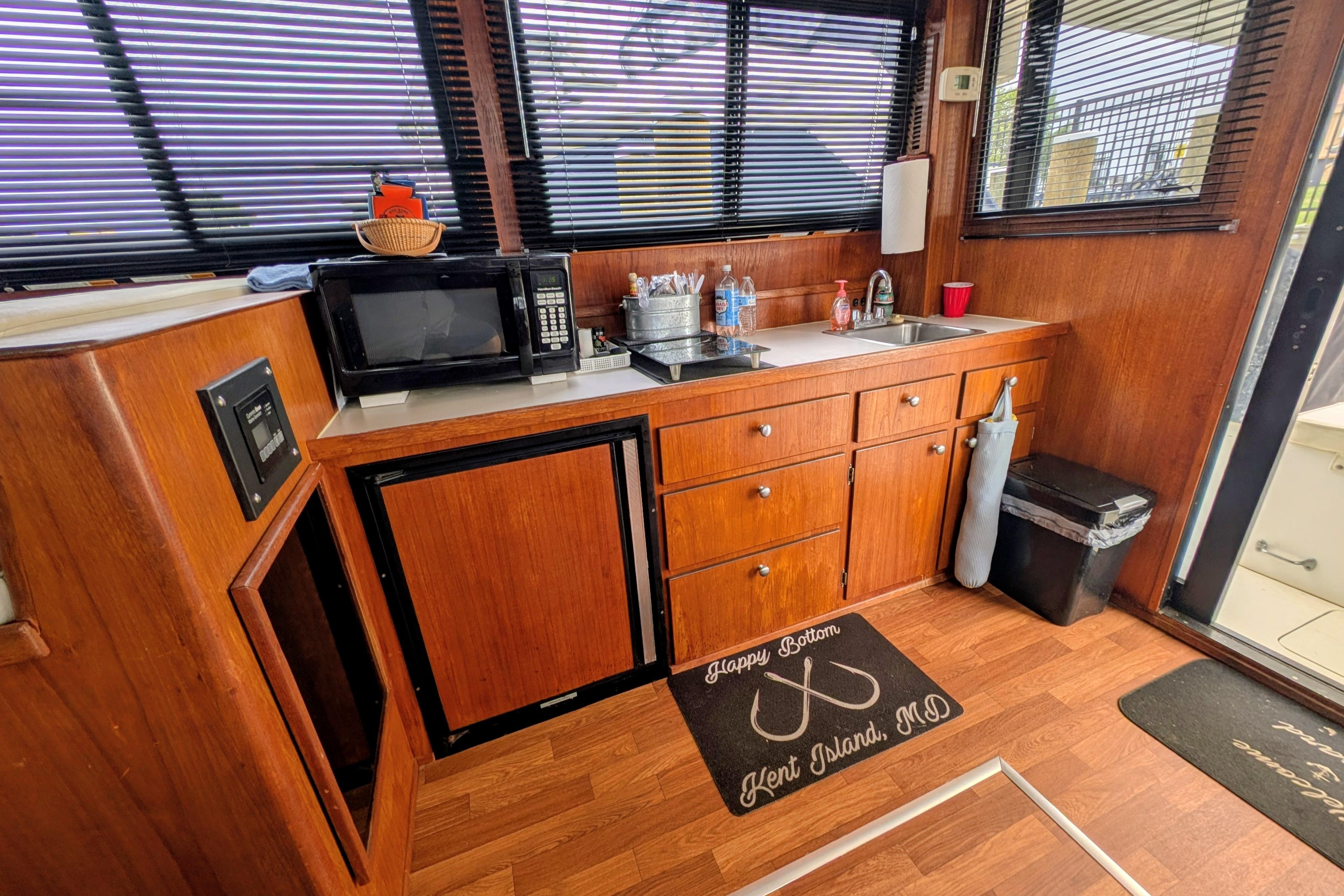 1998 Markley 46 boat interior kitchen with wood cabinets, microwave, and sink.