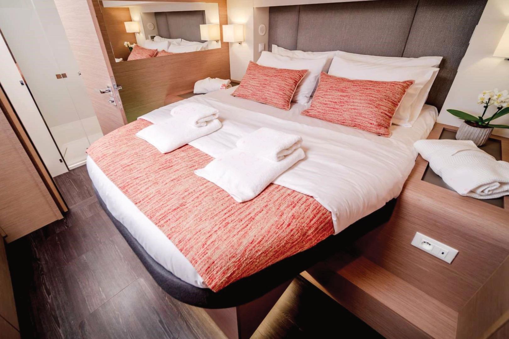 Luxurious bedroom interior on 2021 Fountaine Pajot Samana 59 yacht, featuring elegant bedding and decor.