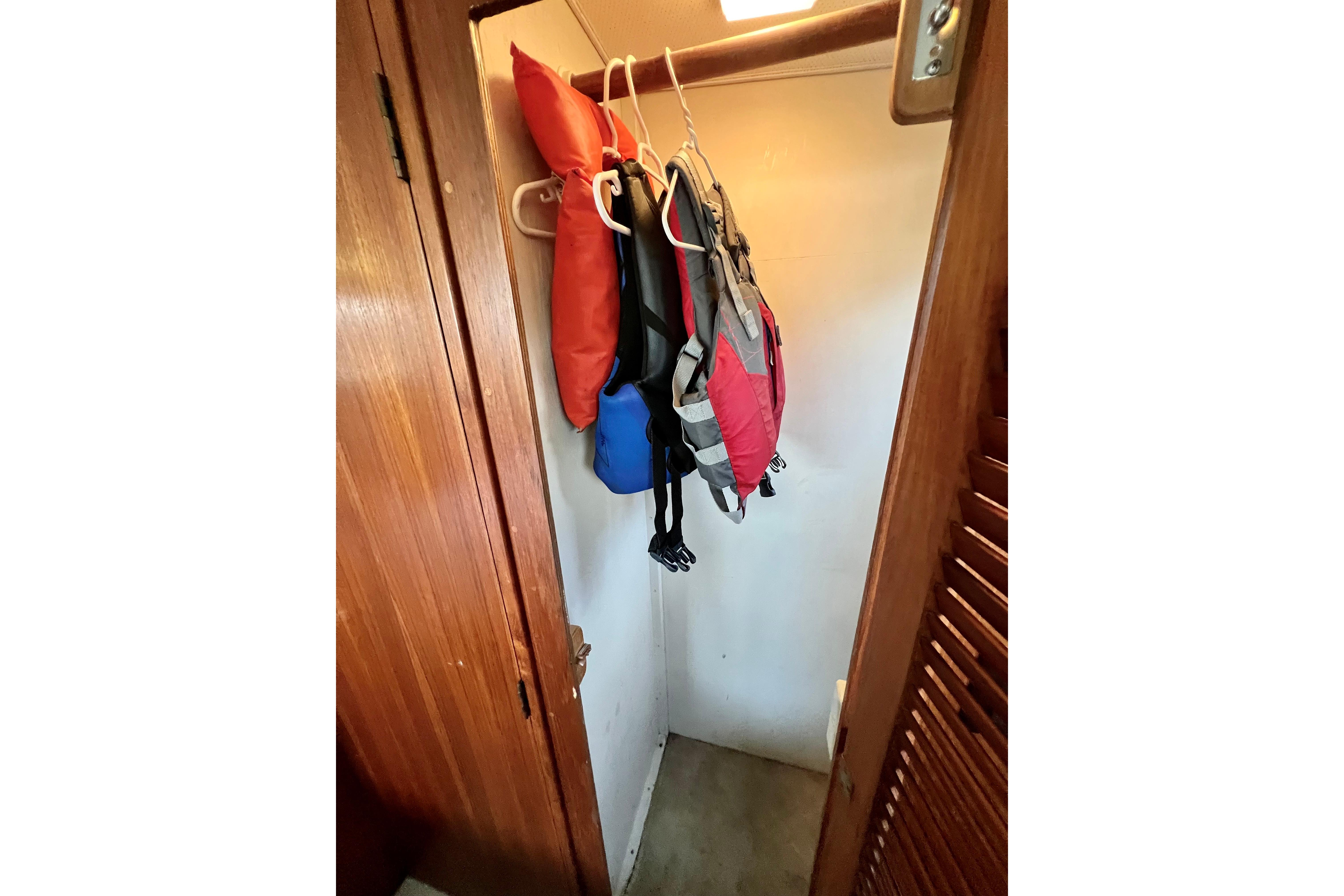 Life jackets hanging in a wooden closet on a 1985 Tollycraft 48 Cockpit Motor Yacht.