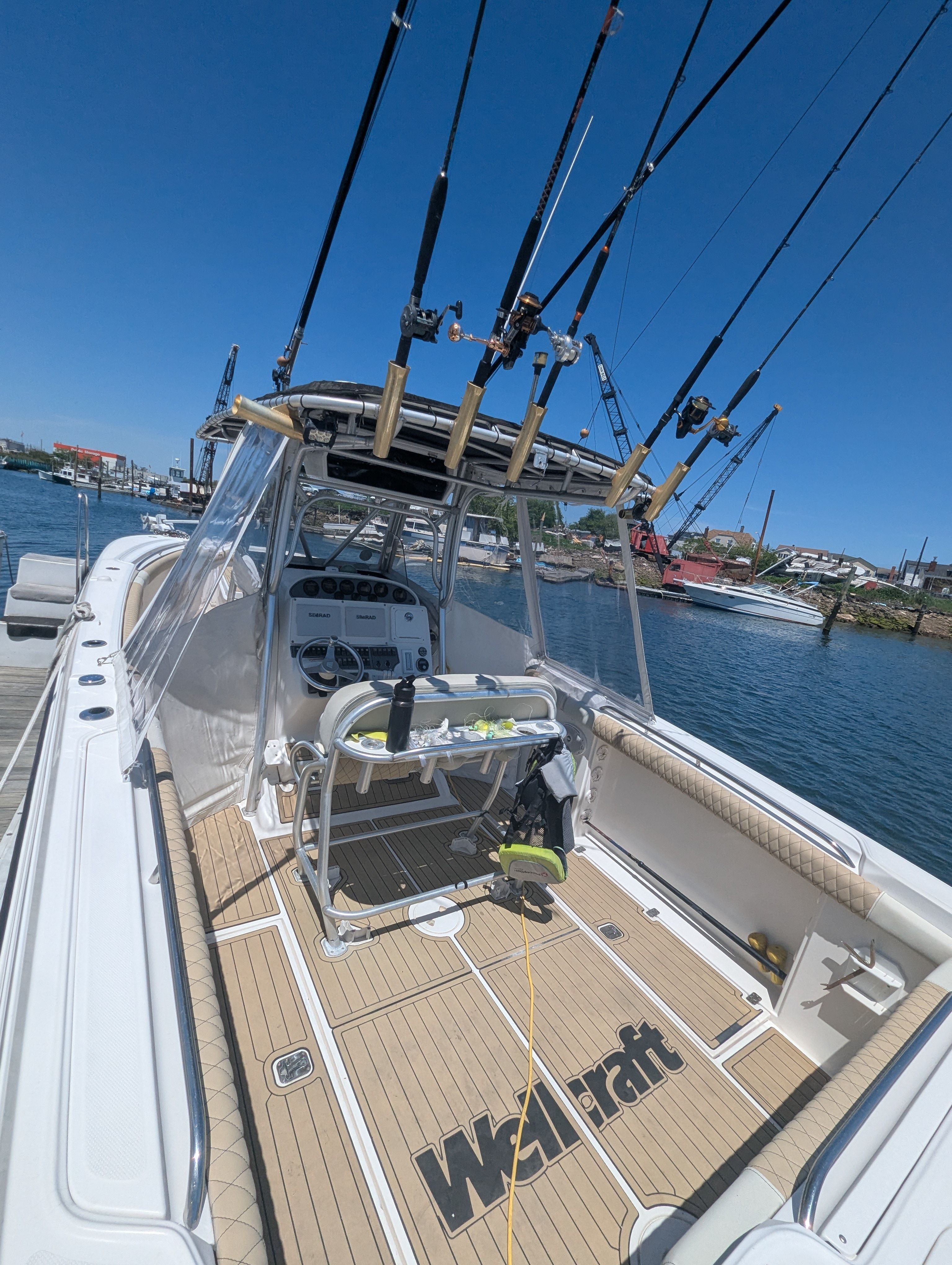 2005 Wellcraft 35 CCF boat with fishing rods at dock.