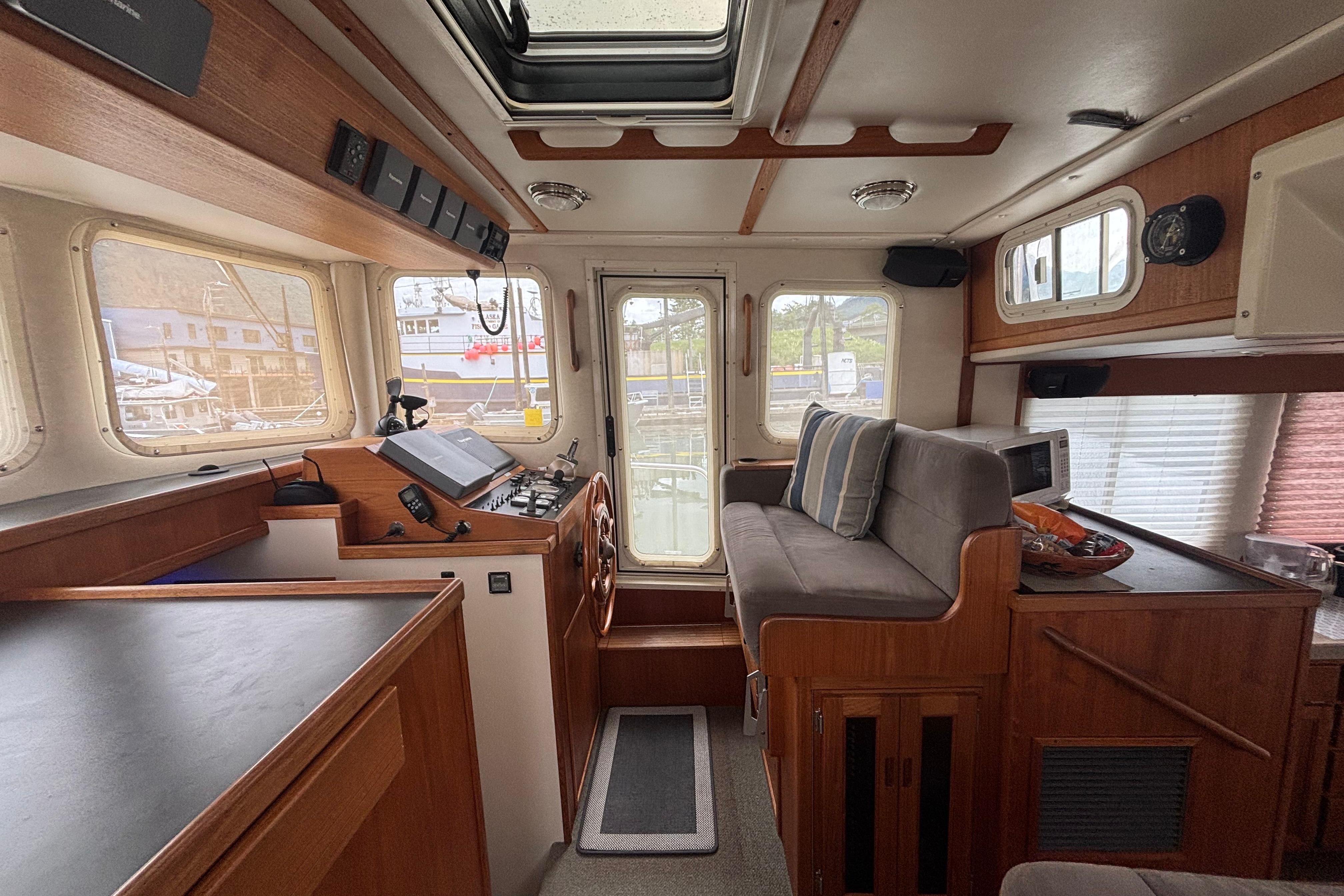 Interior of a 2004 Nordic Tug 37, featuring a cozy helm and seating area.