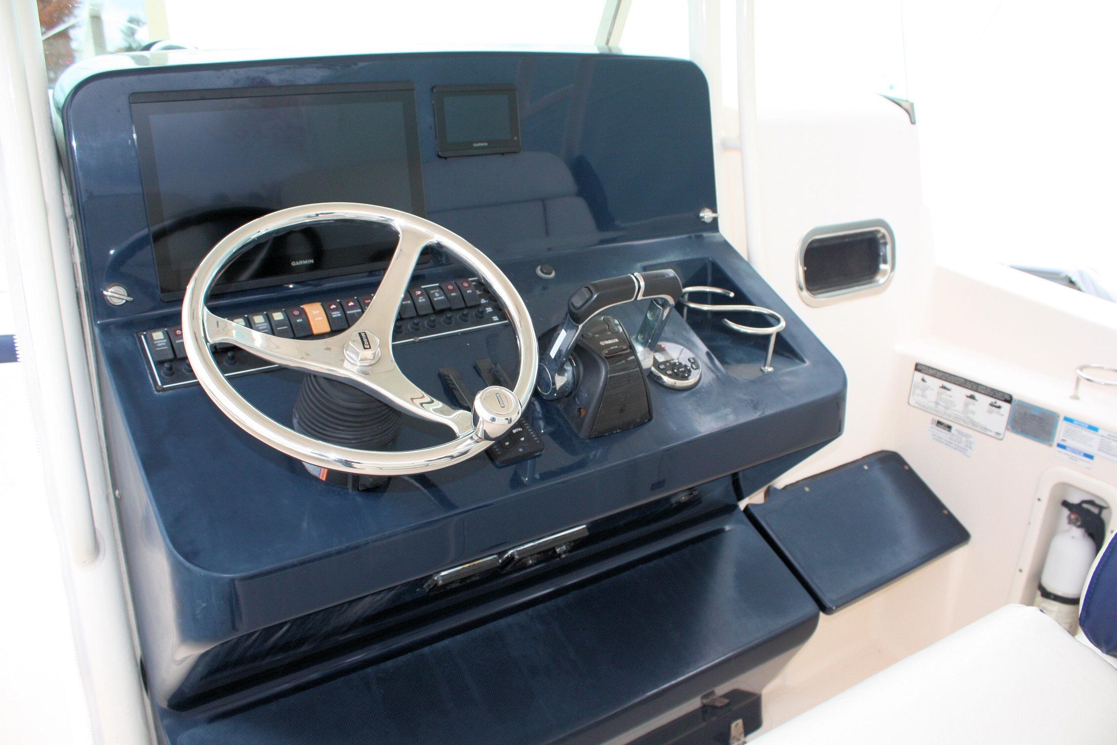 2013 Pursuit ST 310 Sport boat helm with steering wheel and controls.