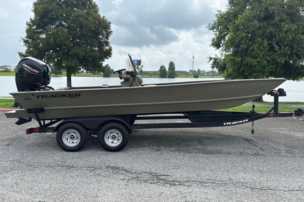 2026 Tracker Grizzly 2072 CC boat on trailer by a lake, overcast sky.