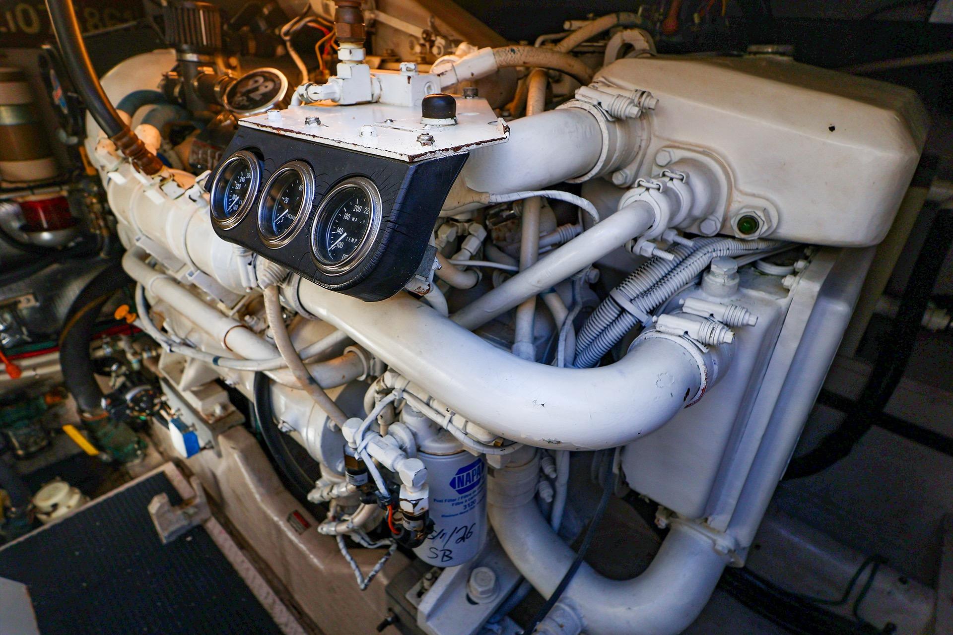Engine compartment of a 1998 Sea Ray 500 Sundancer yacht, showcasing gauges and piping.