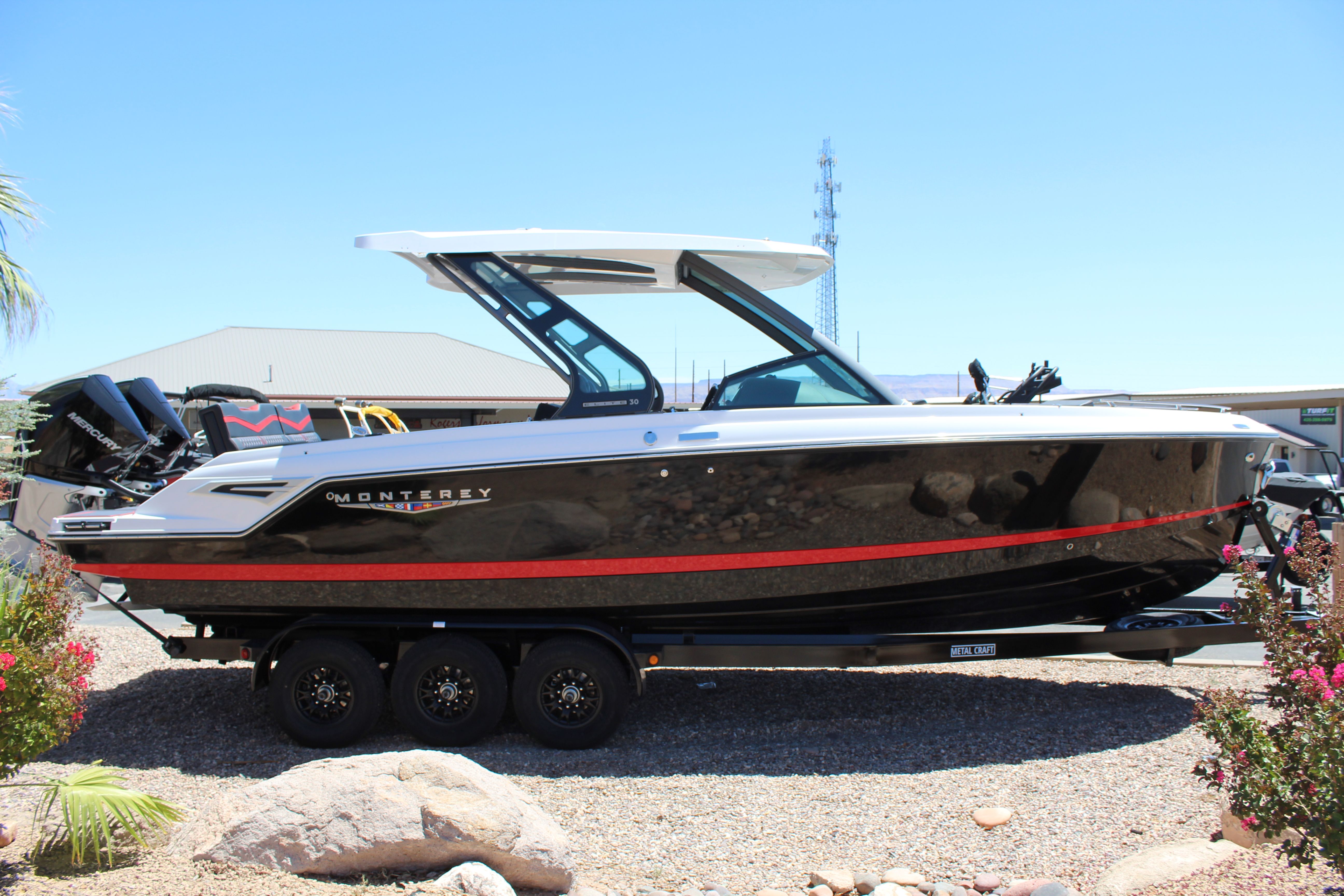 2025 Monterey Elite 30 OB boat on trailer, side view.