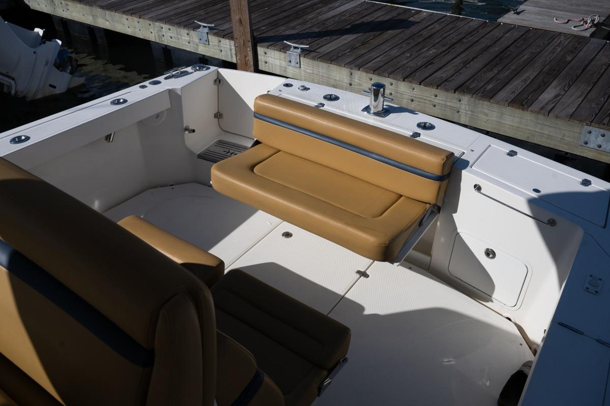 2016 Hunt Yachts 32 Center Console with tan seating, docked at a wooden pier.