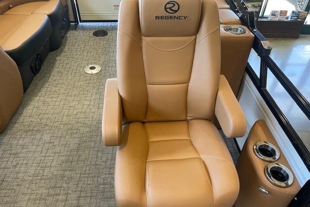 Luxurious tan seat in 2026 Regency 230 DL boat interior, featuring cup holders and armrests.