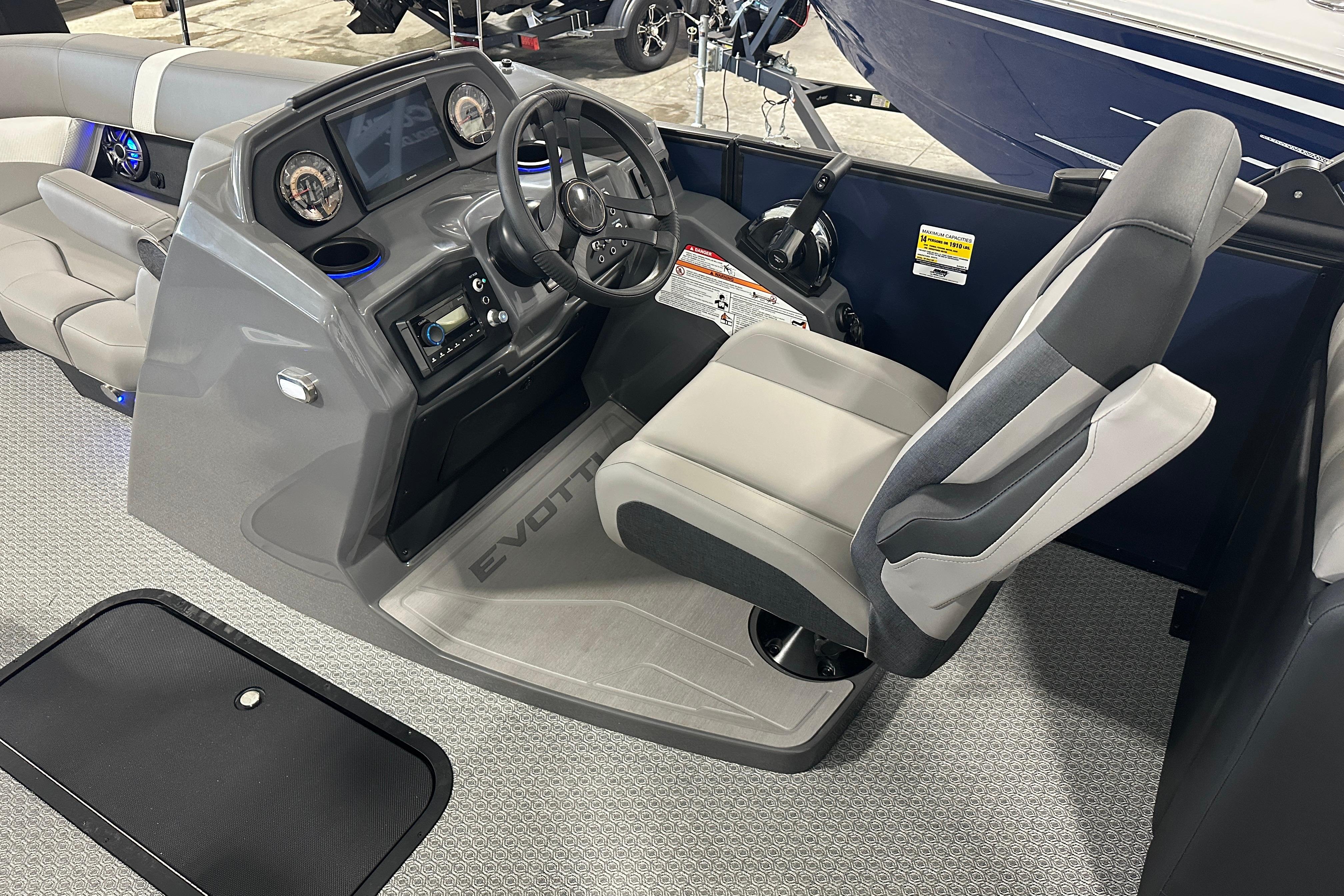 Captain's seat and dashboard of 2026 Evotti 523QL boat, featuring modern controls and design.