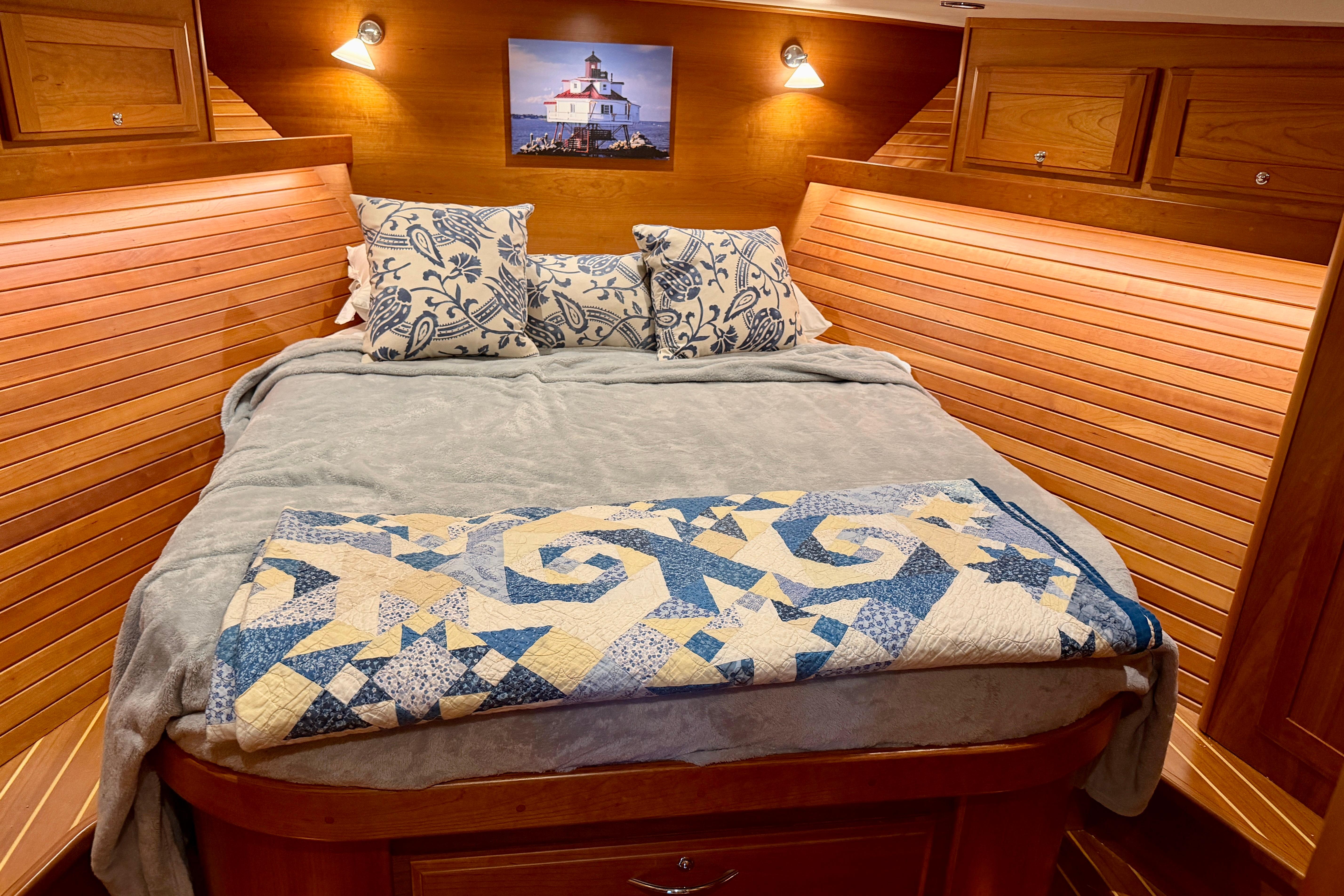 Cozy bedroom in 2016 Sabre 48 Salon Express yacht with nautical decor and wooden paneling.
