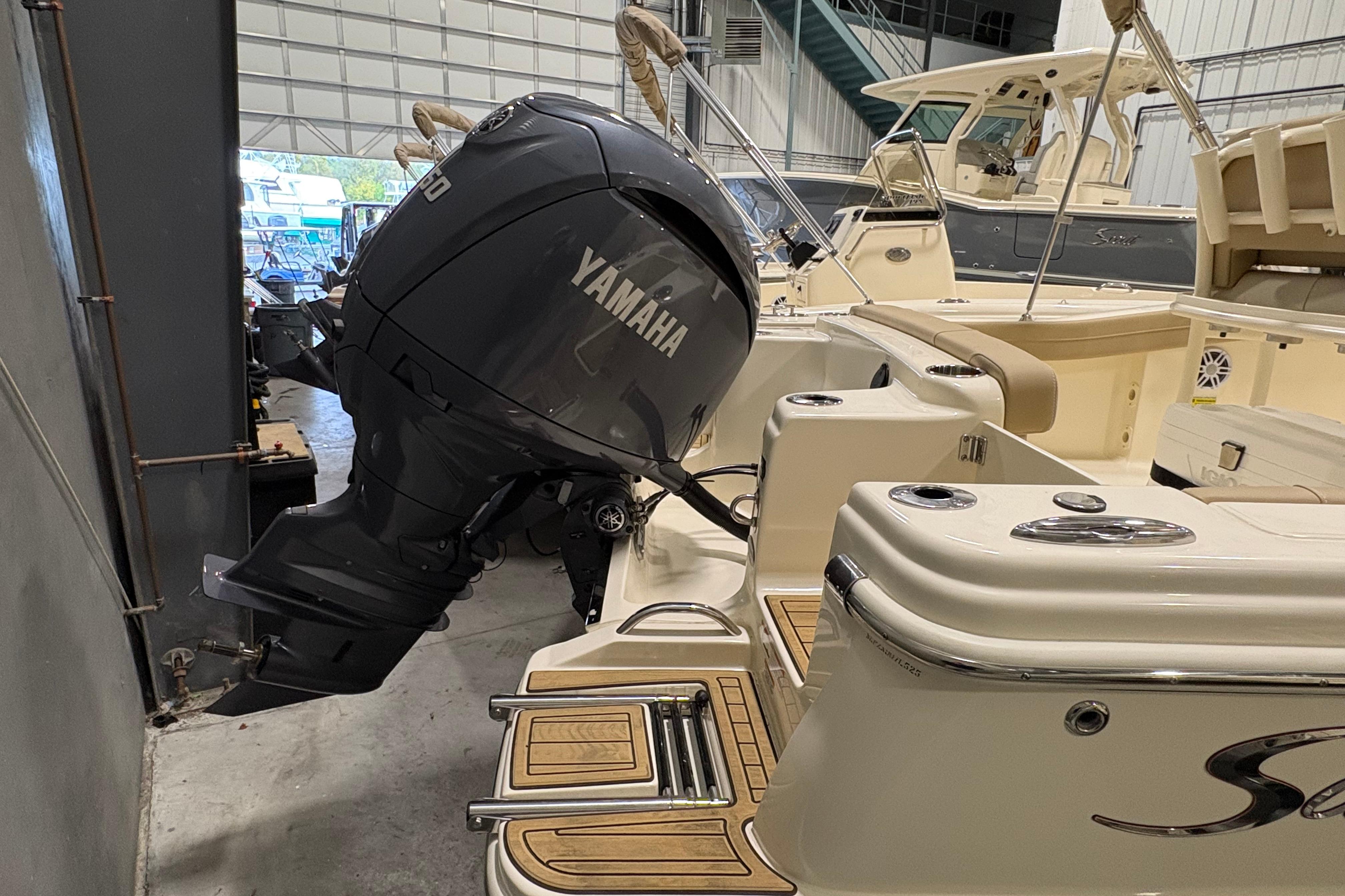 2025 Scout 215 XSF boat with Yamaha outboard motor in a storage facility.