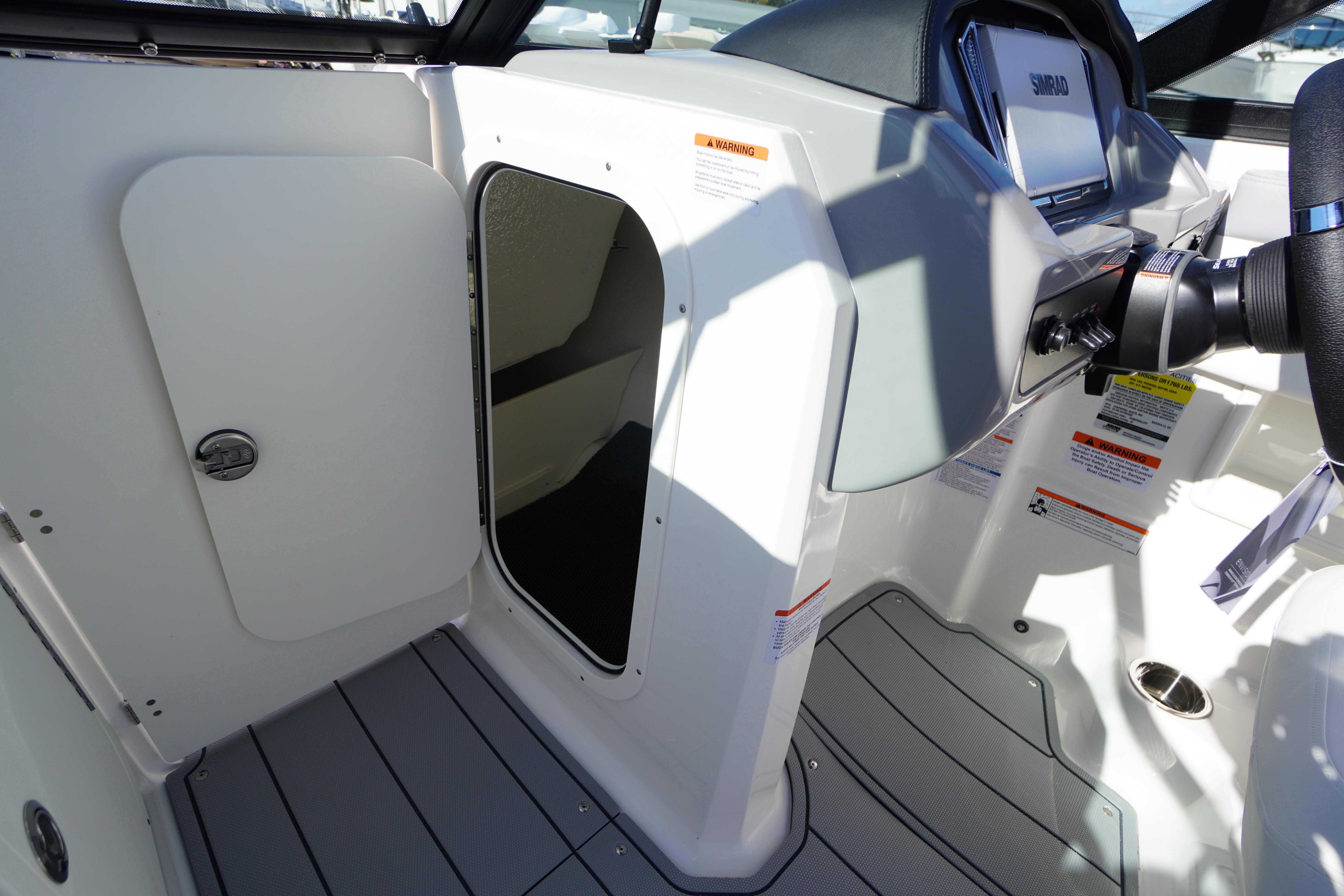 2026 Chaparral 23 SSi OB boat interior with helm and storage compartment.