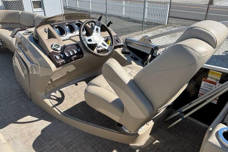 2014 Bennington 2575 RCW boat interior with steering console and beige seating.