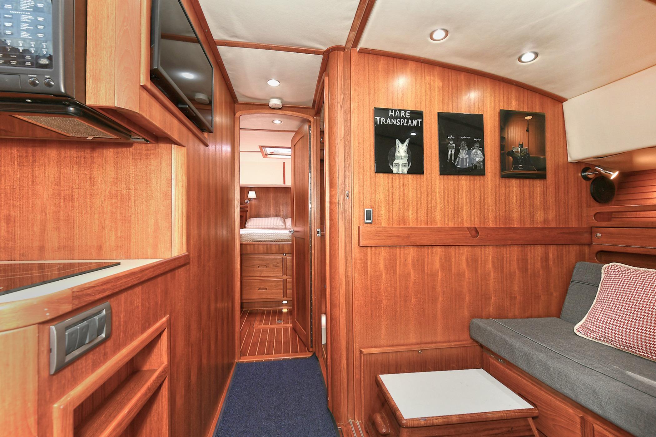 Interior of 2005 San Juan Downeast Express yacht with wood paneling and cozy seating area.