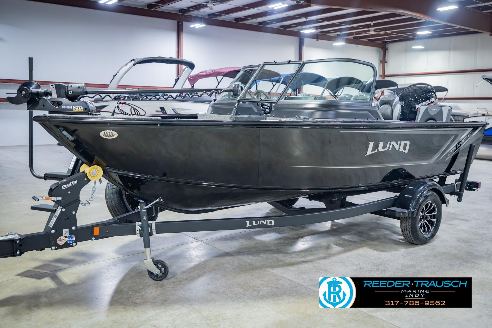 2026 Lund 1775 Impact XS boat in showroom, featuring sleek design and modern equipment.