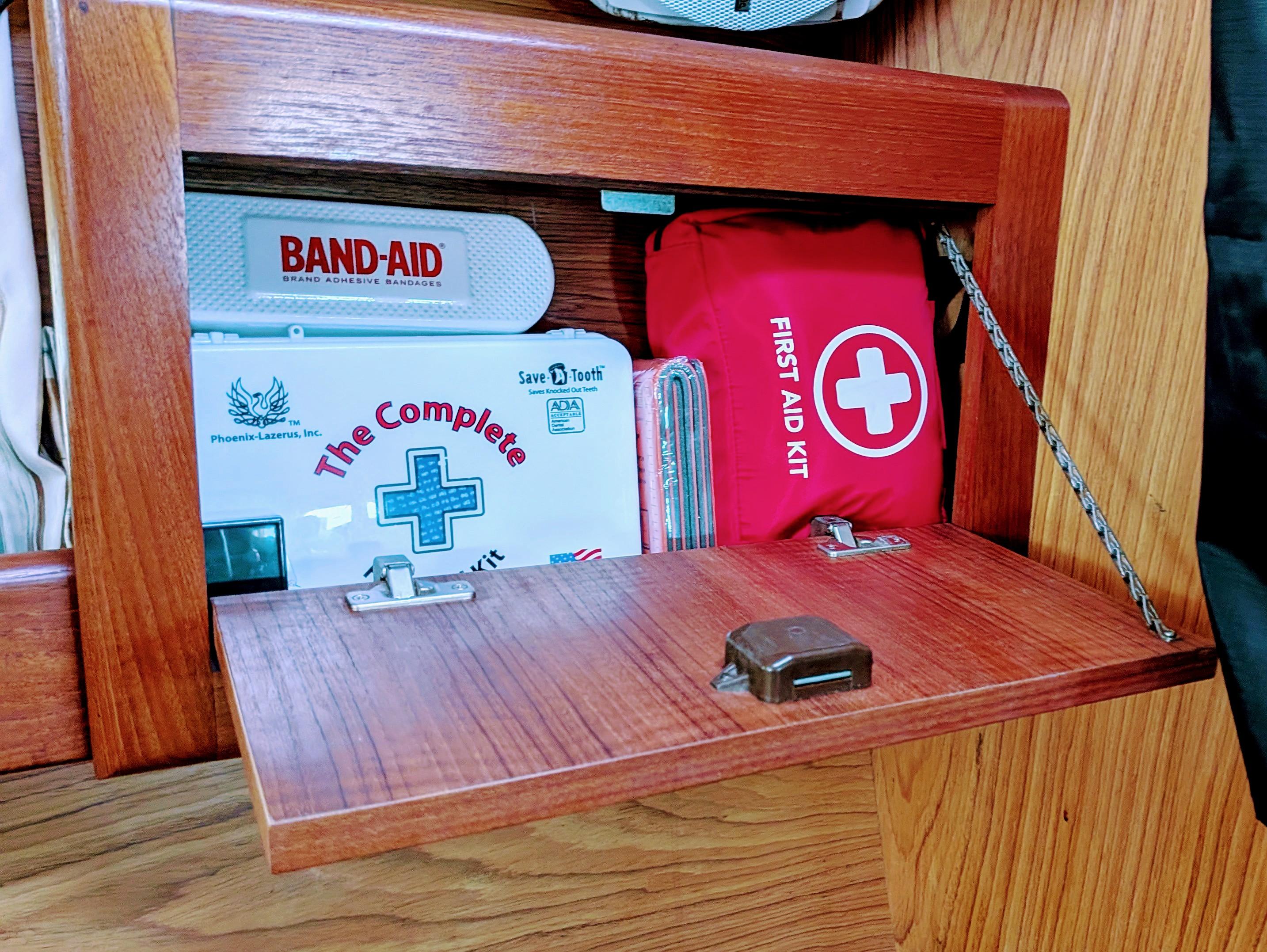 First aid kits in a wooden cabinet on a 2001 Hunter 380 boat.