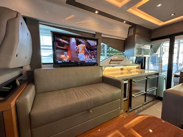Interior of 2019 Tiara Yachts C53 with TV, sofa, and modern kitchen.