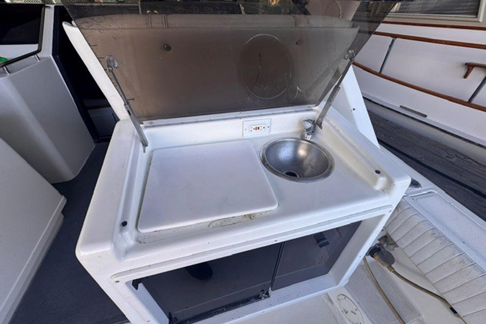 1988 Tiara Yachts 3300 Open boat sink and counter area with storage.