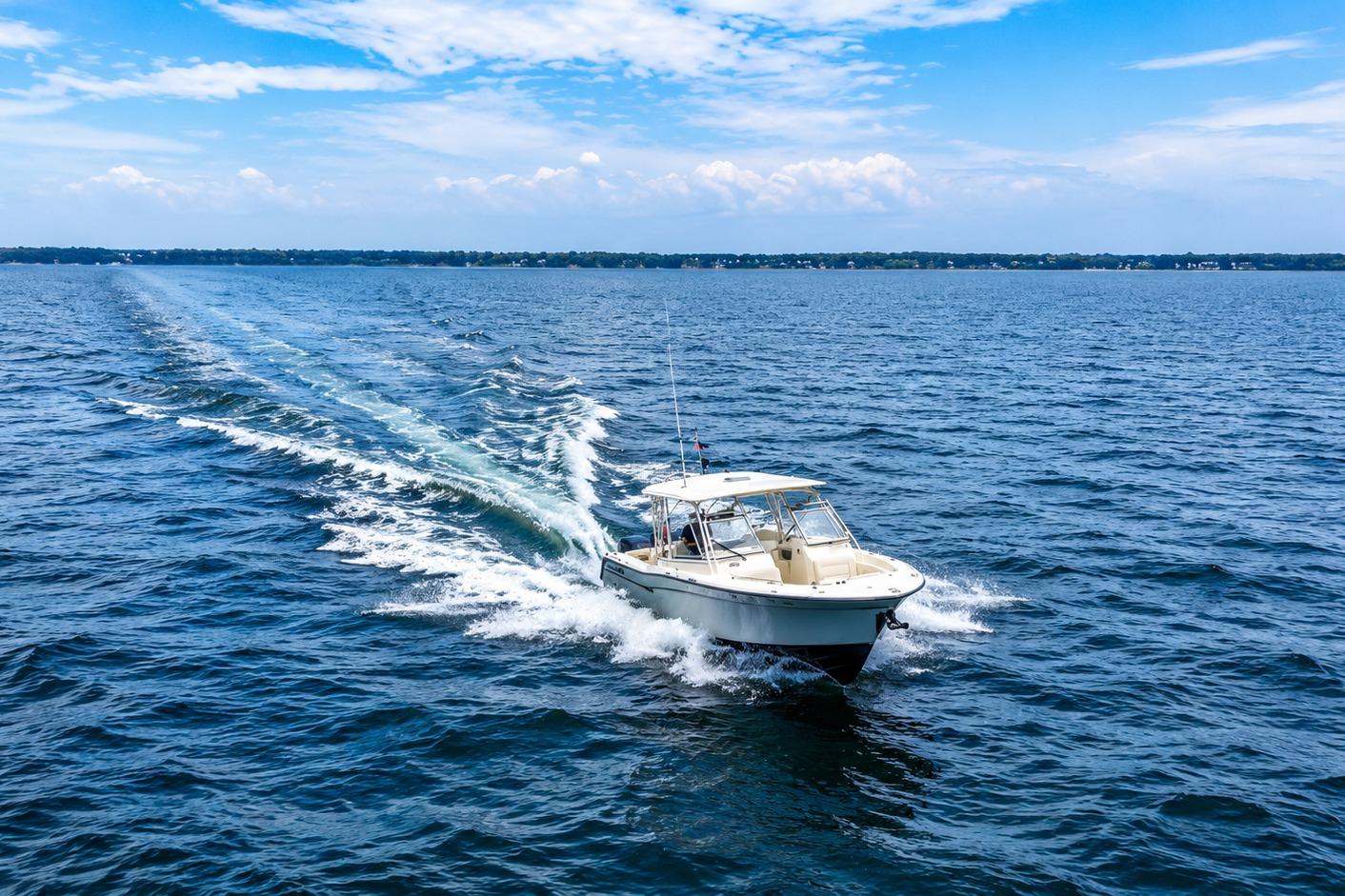 2019 Grady-White Freedom 307 cruising on open water under a clear blue sky.