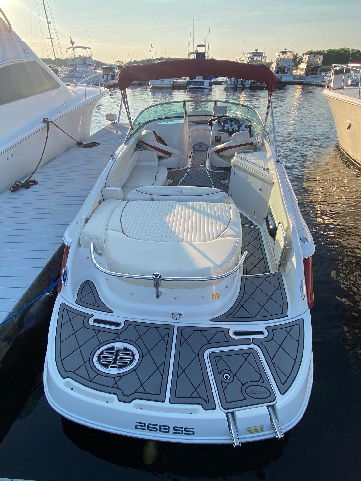 A 2006 Monterey 268SS Super Sport docked. It features a spacious cockpit and cushioned sun pad.