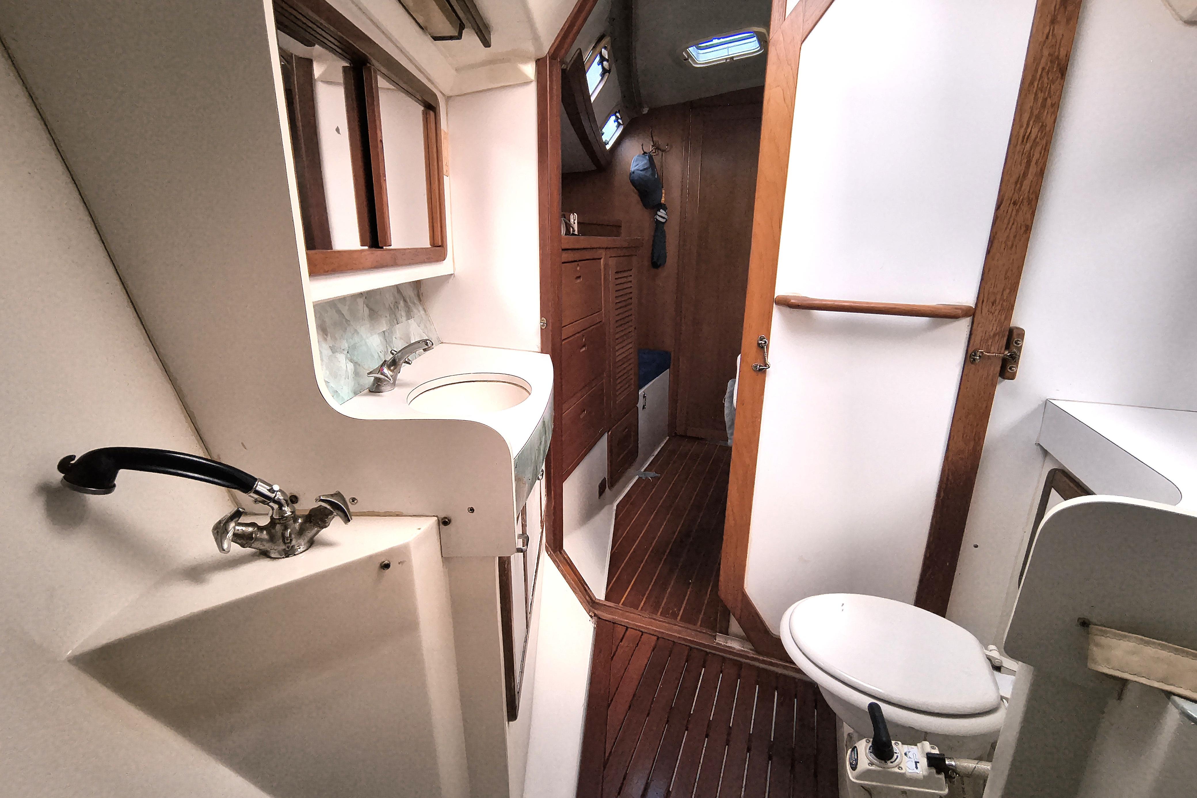 Interior of 1993 Catalina 42 sailboat bathroom with sink, toilet, and wooden accents.