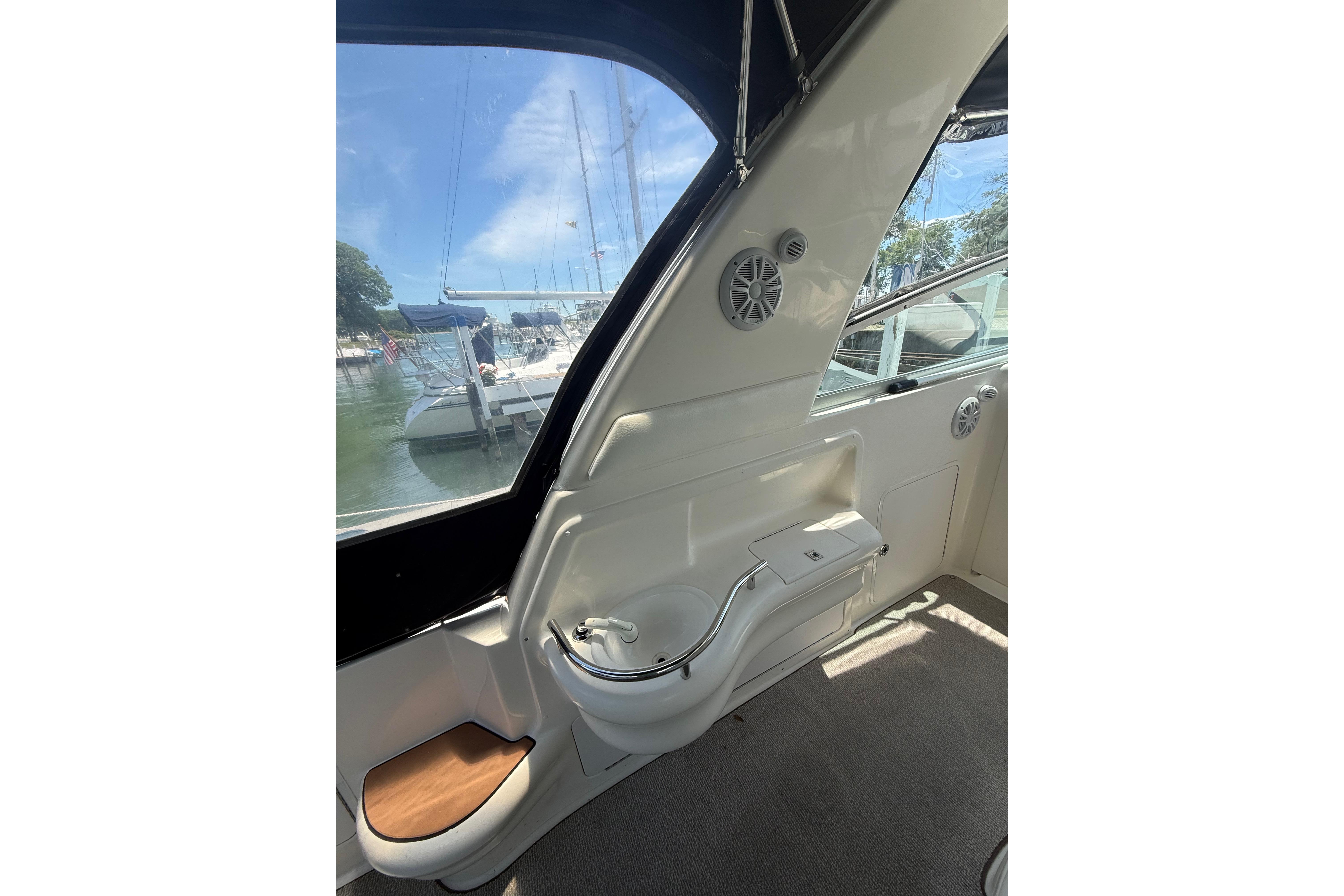 Interior view of a 1999 Sea Ray Sundancer 310 yacht, showcasing sleek design and marina backdrop.