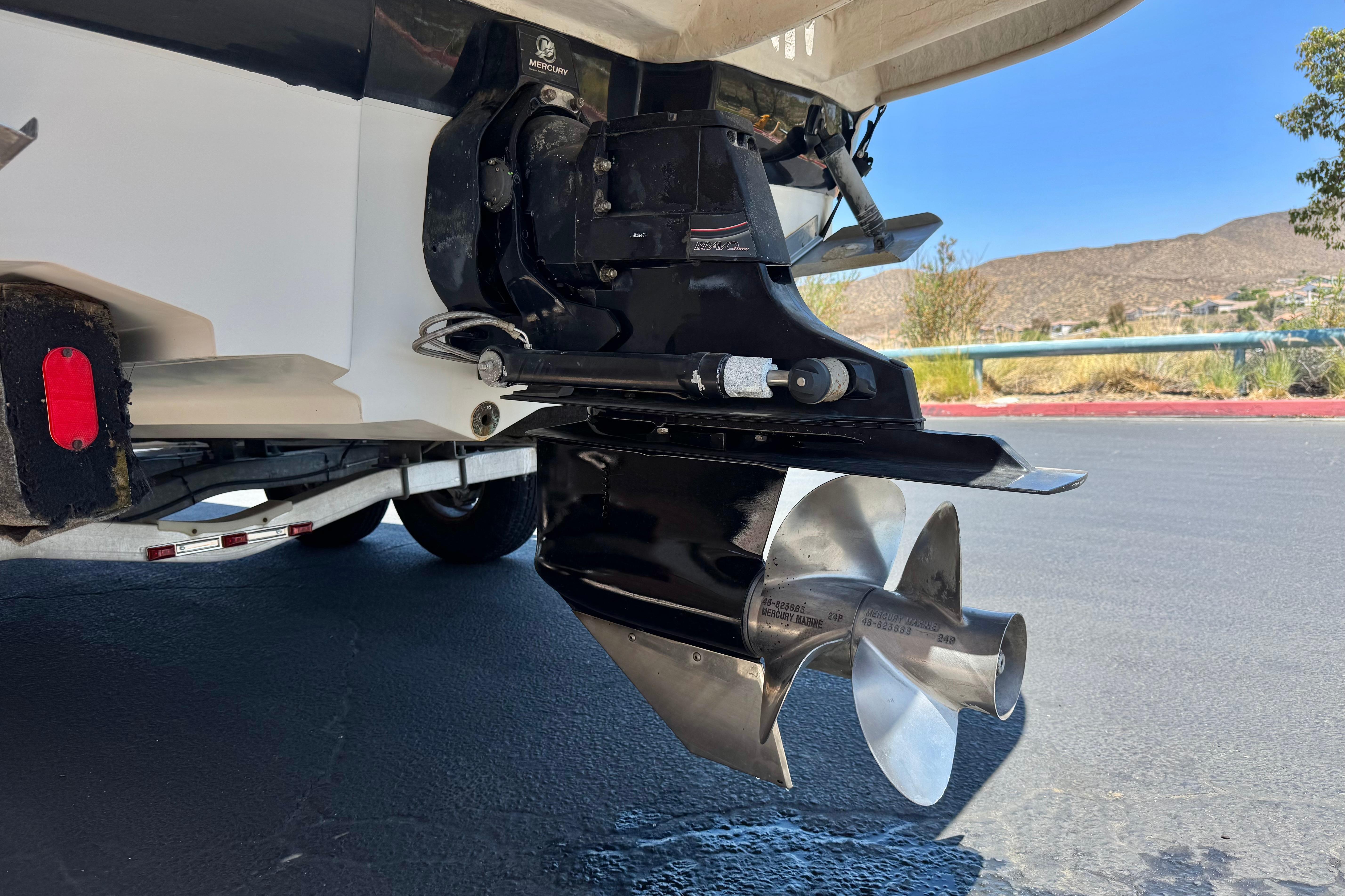 2007 Sea Ray 240 Sundeck boat propeller and stern drive, parked on a trailer.
