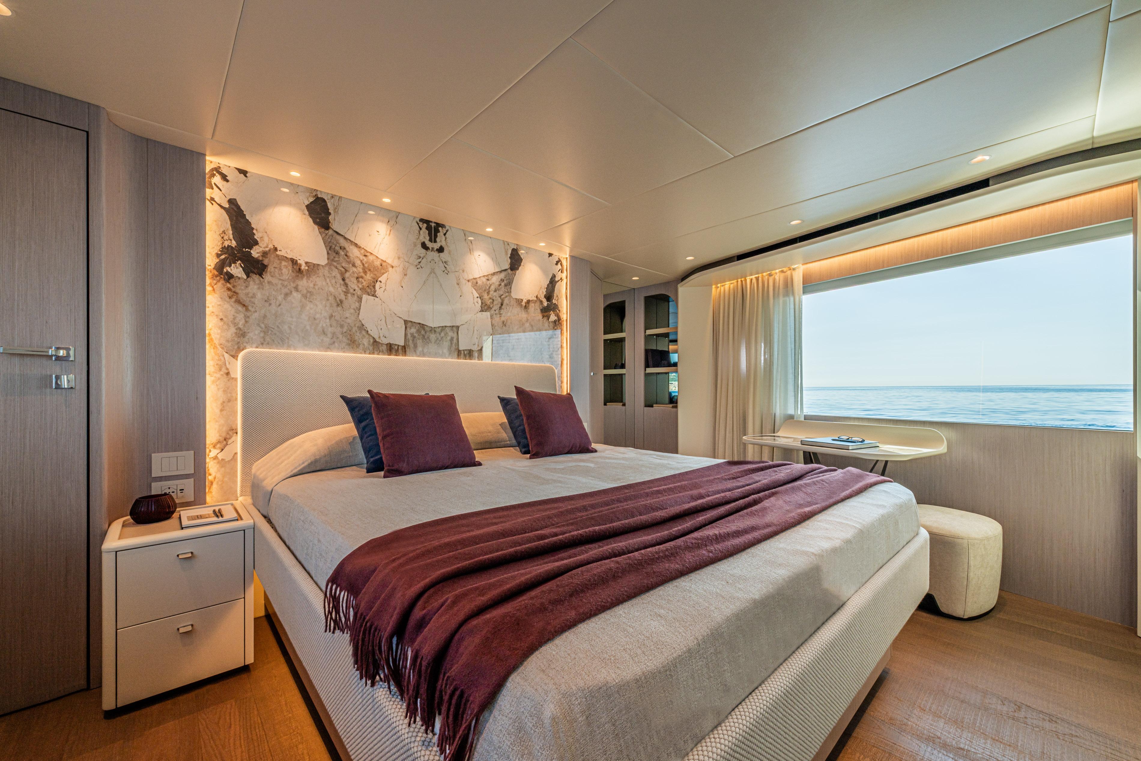 Luxurious bedroom interior of 2026 Absolute Navetta 62 yacht with ocean view.