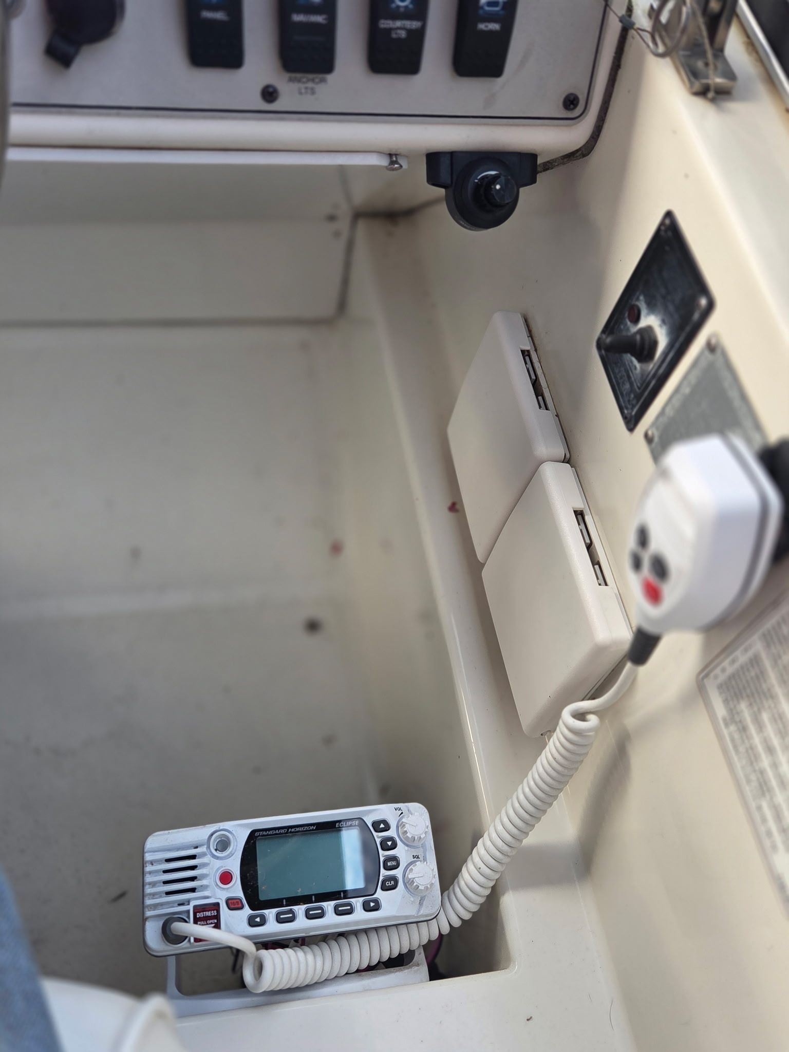 Interior view of a boat with a radio and switches.
