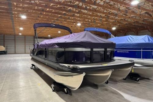 2026 Bennington 22SXSB pontoon boat with cover in spacious indoor storage facility.