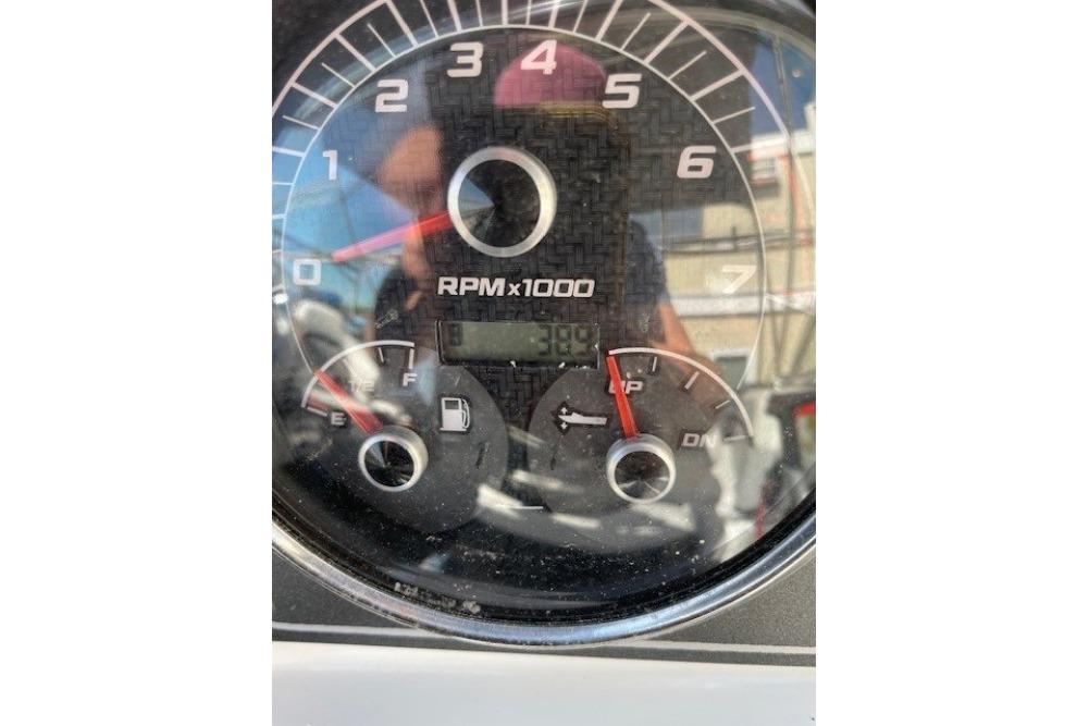 Close-up of 2023 Hurricane SunDeck 217 OB tachometer displaying RPM and fuel gauge.