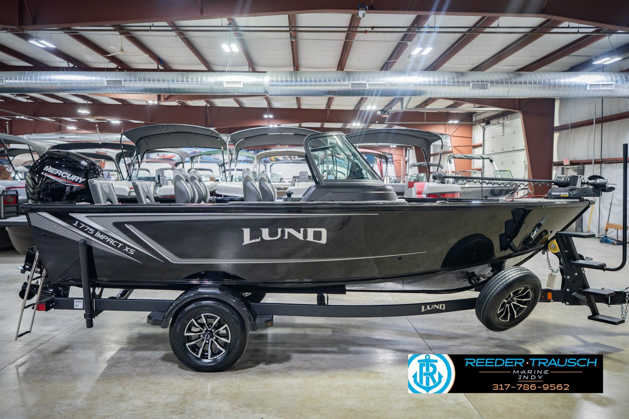 2026 Lund 1775 Impact XS boat in showroom, side view, on trailer.