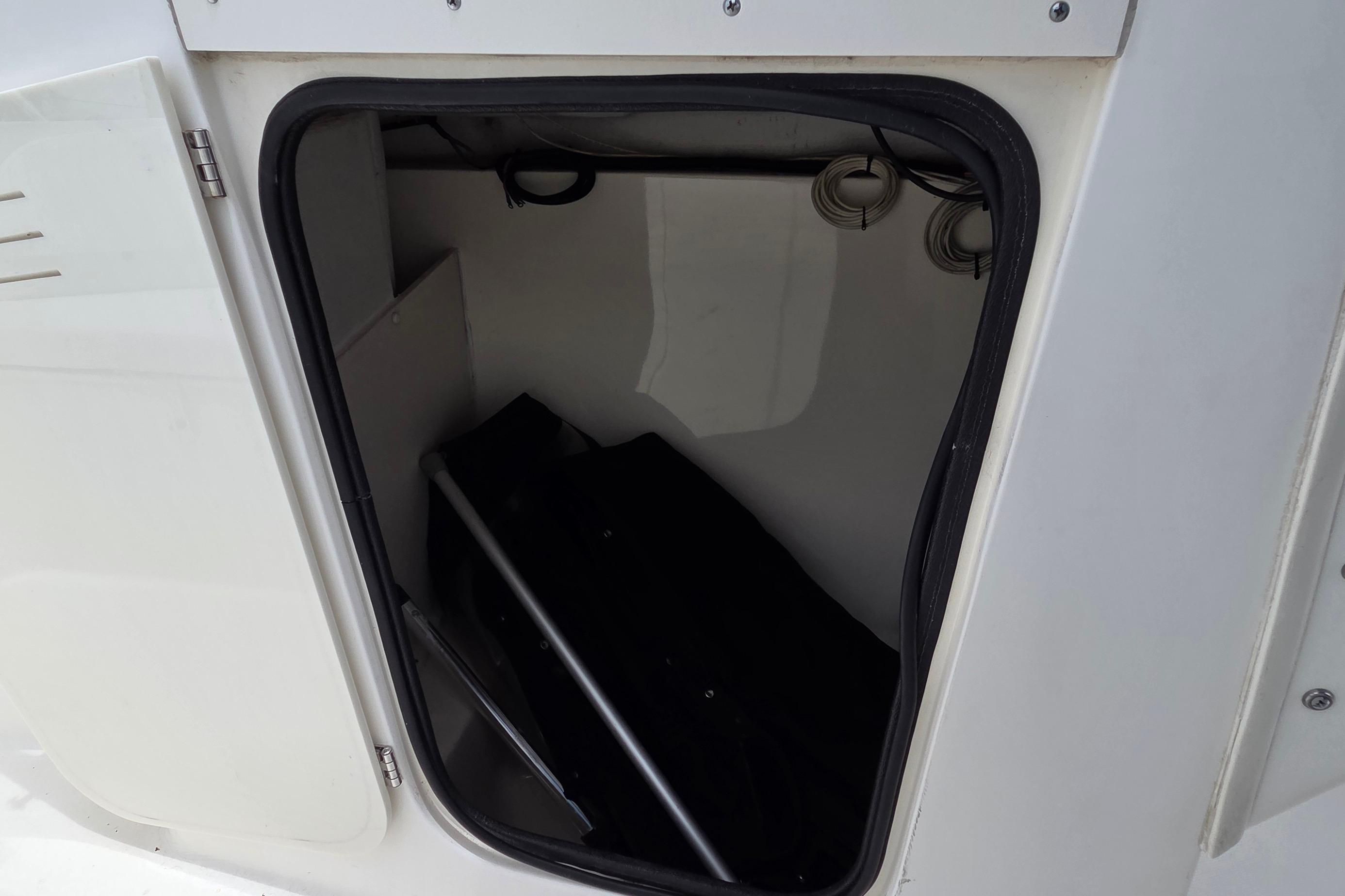 Storage compartment of a 2000 Boston Whaler 21 Ventura boat, partially open.