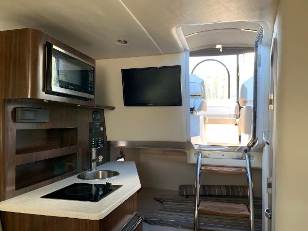 Interior of the Regal 26 Express with kitchenette, microwave, and TV.