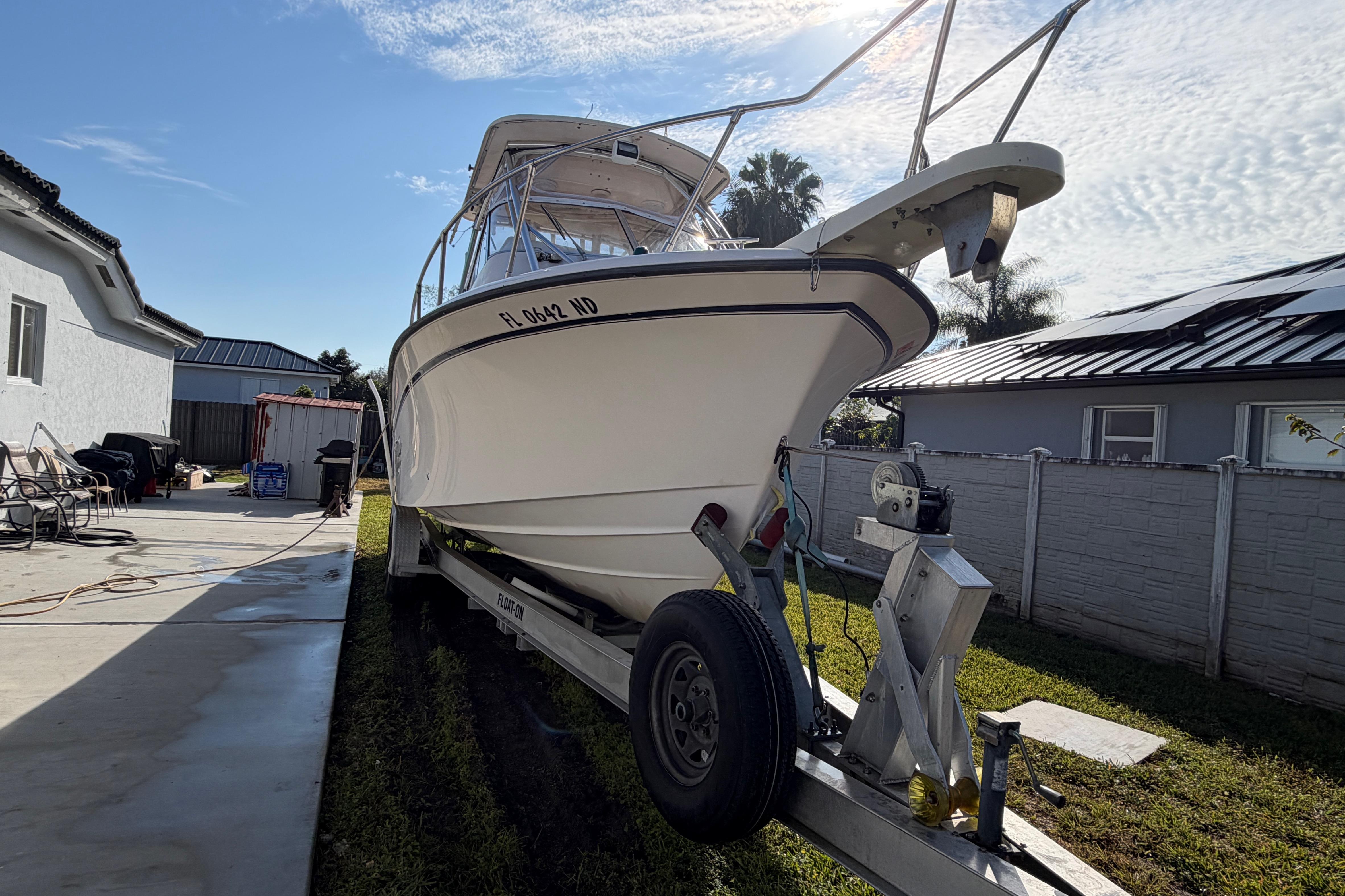 2006 Grady-White Sailfish 282 boat on trailer in residential driveway.