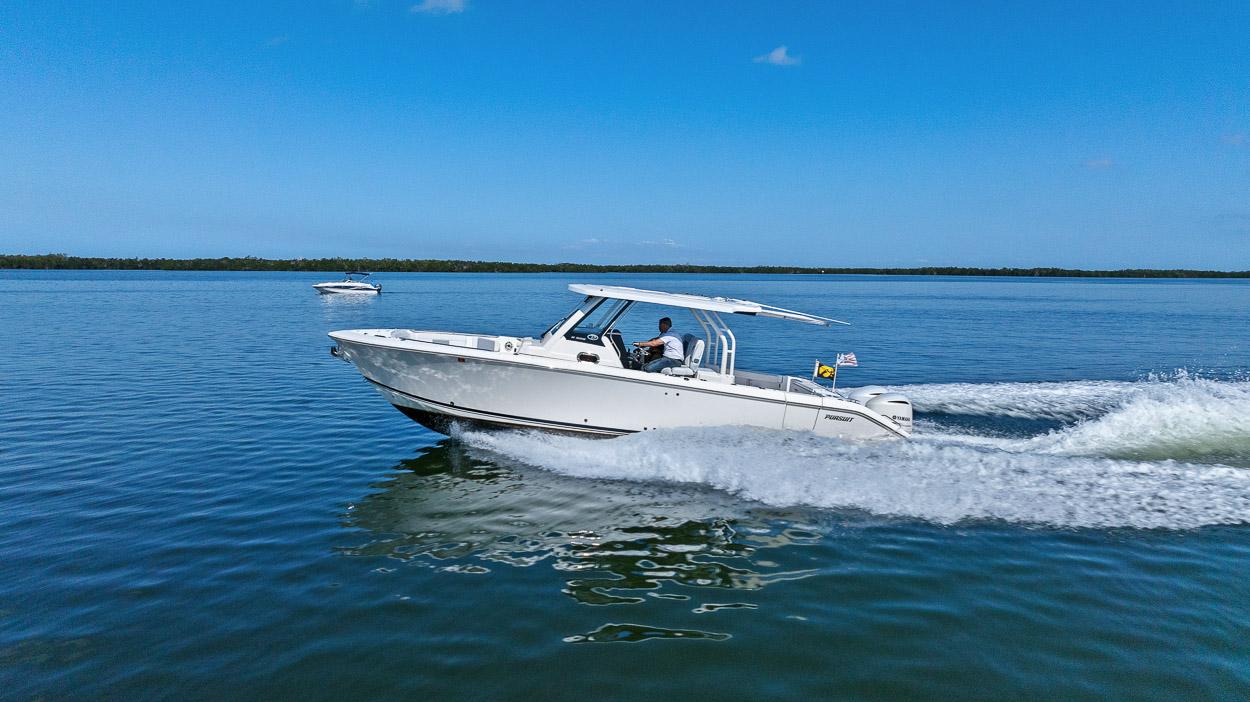 2021 Pursuit S 328 Sport boat cruising on calm blue water.