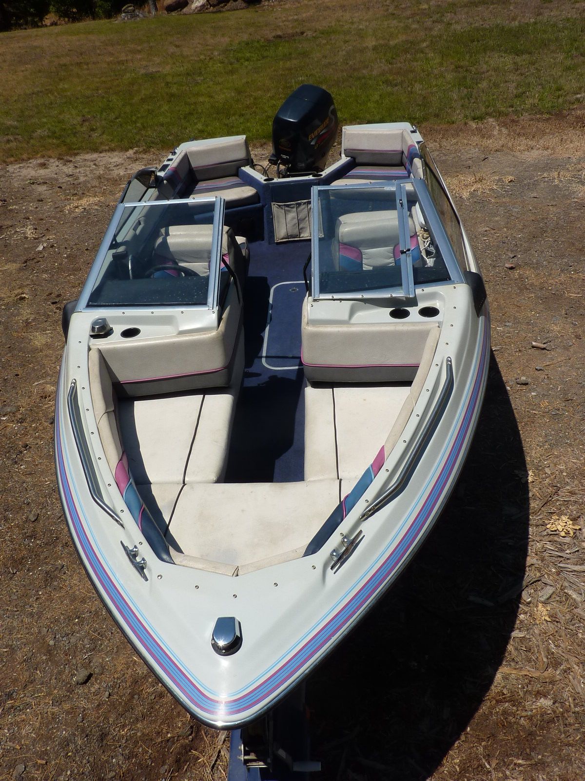 A 1989 Bayliner CAPRI on dry land. It features an open cabin with seating.