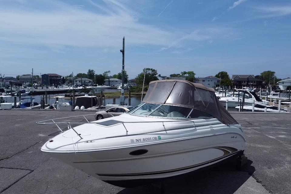 2001 Sea Ray 245 Weekender boat docked at a marina under a clear sky.