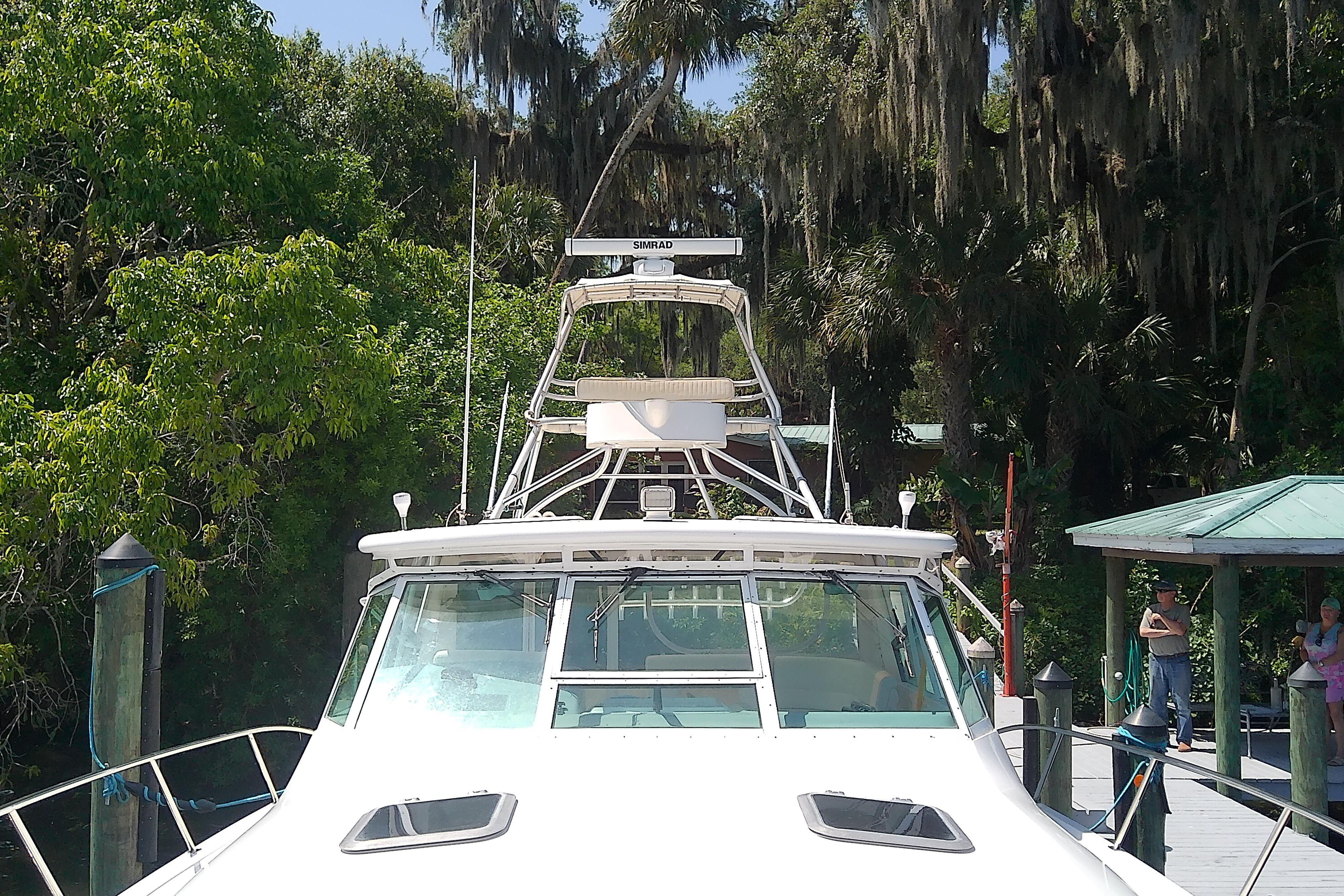 2000 Tiara Yachts 4100 Open docked amidst lush greenery.