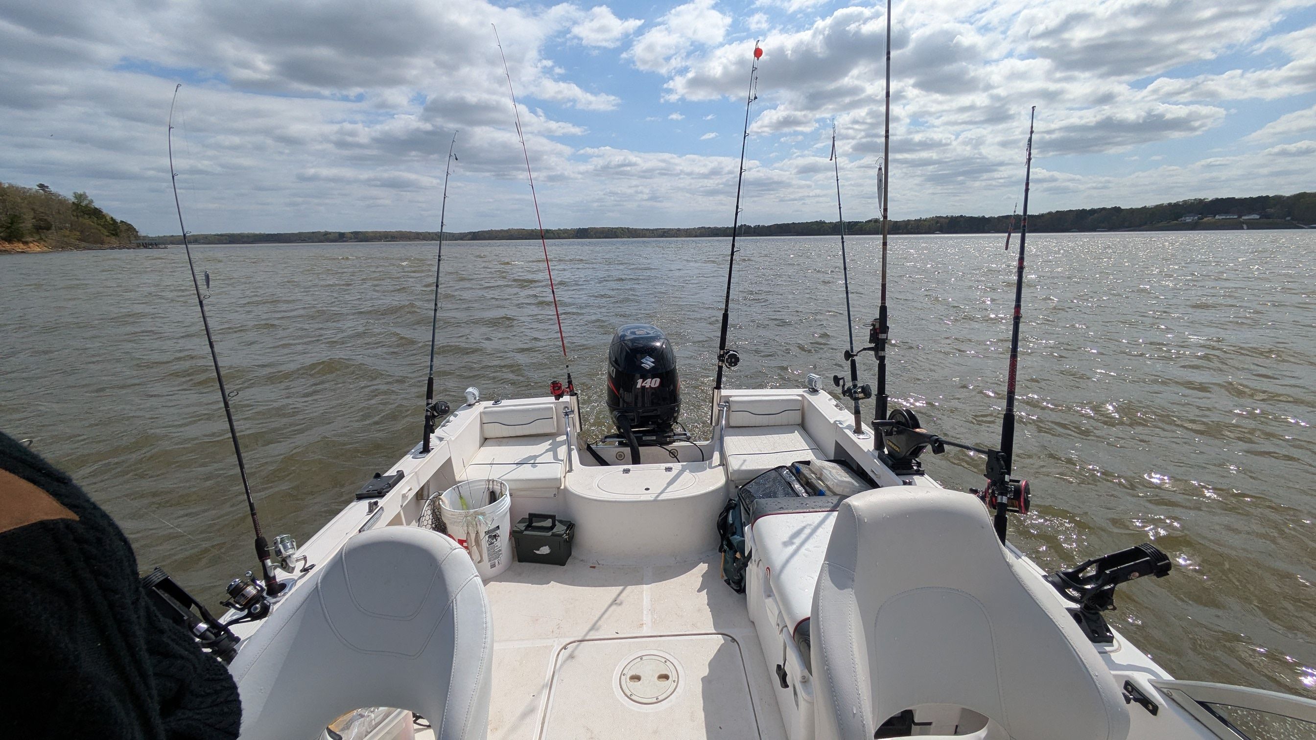 Sea Hunt Escape 200 boat on a lake, fishing rods ready.