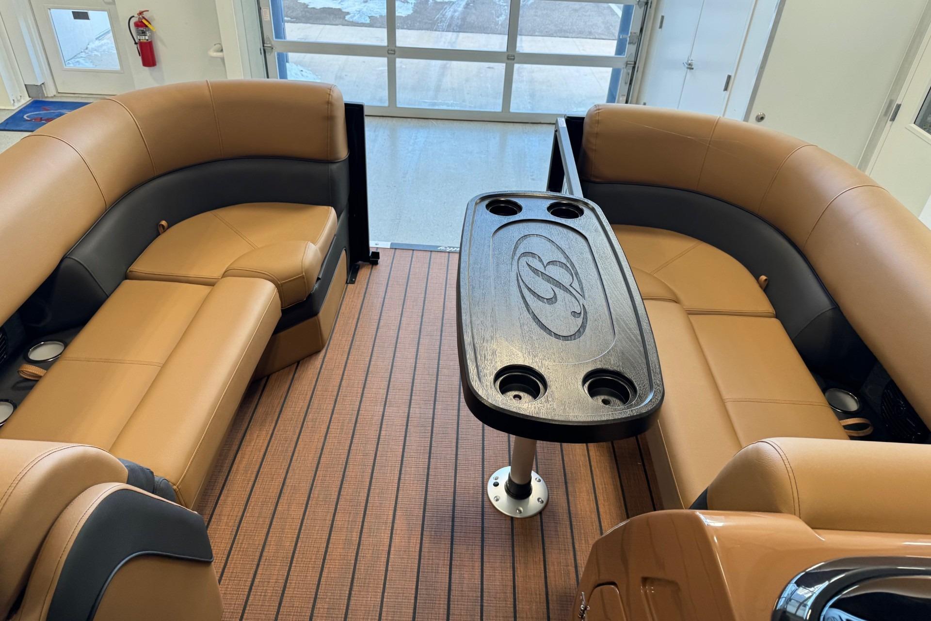 Luxurious interior of 2026 Bentley Pontoons Elite 223 Swingback with tan seating and central table.